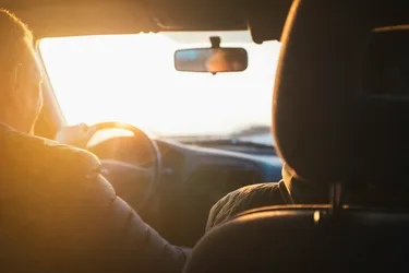 People driving a car in the sun. The car has XPEL PRIME automotive window tint film.