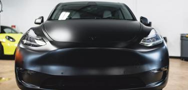 A black 2022 Tesla Model Y is transformed and protected with full coverage STEALTH PPF, providing a sleek, satin finish.