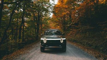 a car on a dirt road surrounded by trees
